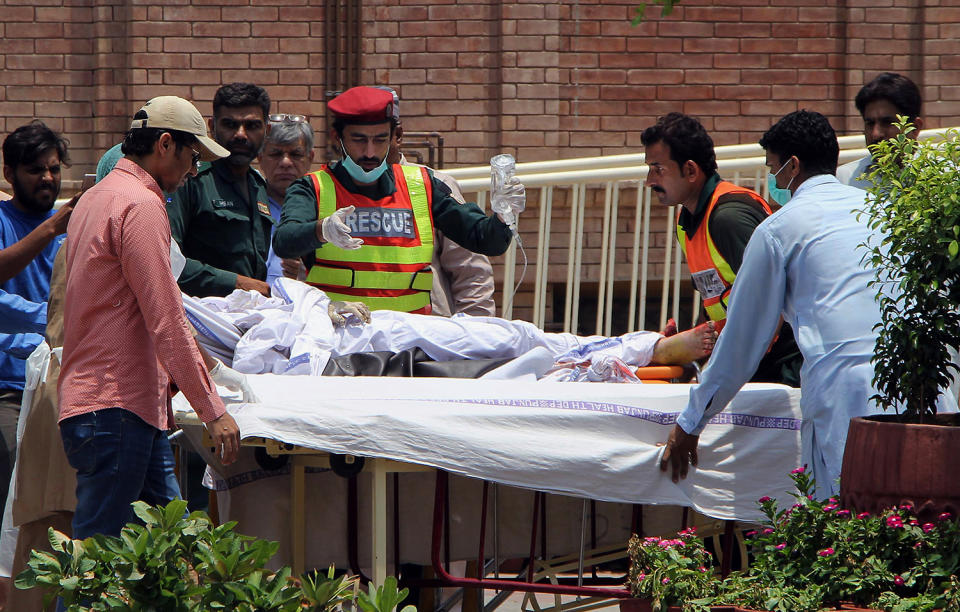 <p>Pakistani rescue worker and hospital staff transport a victim of an oil tanker explosion at a hospital in Multan, Pakistan, Sunday, June 25, 2017. An overturned oil tanker burst into flames in Pakistan on Sunday, killing scores of people who had rushed to the scene of the highway accident to gather leaking fuel, an official said. (AP Photo/Adeel Khan) </p>