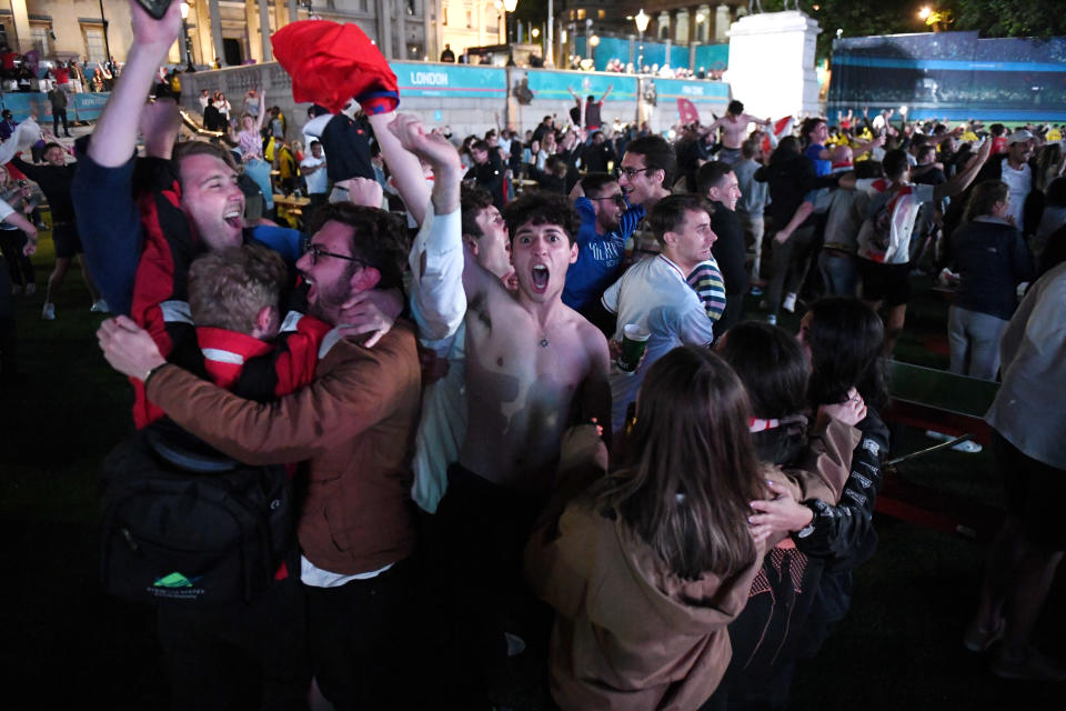 Three Lions fans celebrate at the Euro 2020 fan zone in London's Trafalgar Square. 