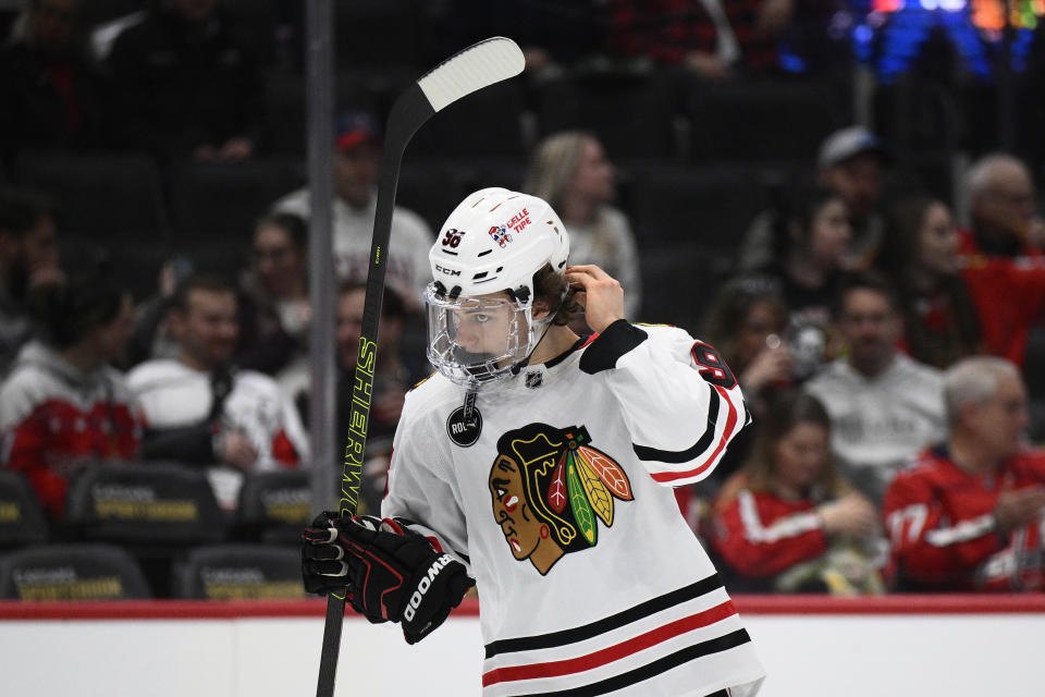 Chicago Blackhawks center Connor Bedard (98) adjusts his helmet before the team's NHL hockey game against the Washington Capitals, Saturday, March 9, 2024, in Washington. (AP Photo/Nick Wass)