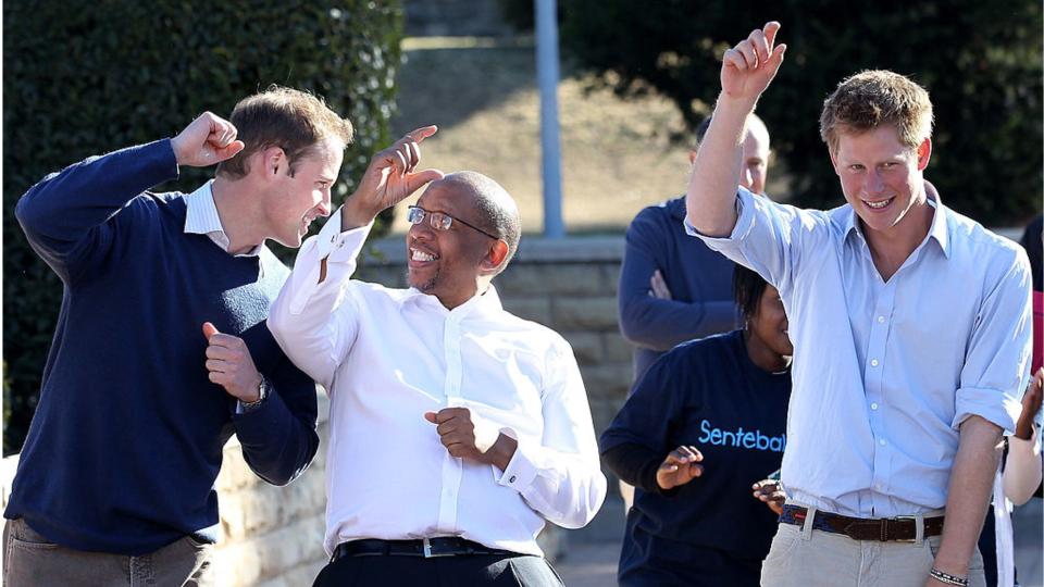 Prince Harry and Prince William dance with Prince Seeiso as they visit the Mamahato Network Club in Lesotho