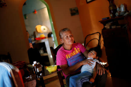 Isabel Buelvas takes a break while she gives a meal to her grandson Kaleth Heredia, 2, a neurological patient being treated with anticonvulsants, at their house in Caracas, Venezuela January 30, 2017. REUTERS/Carlos Garcia Rawlins