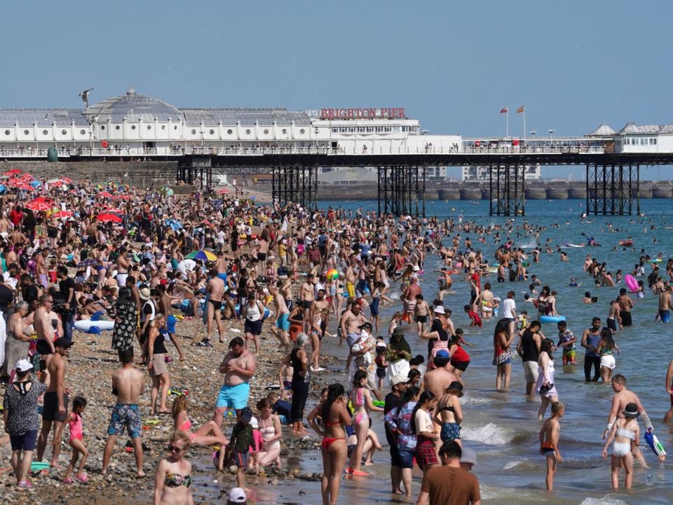 Beachgoers enjoy the warm weather in Brighton (Gareth Fuller/PA)