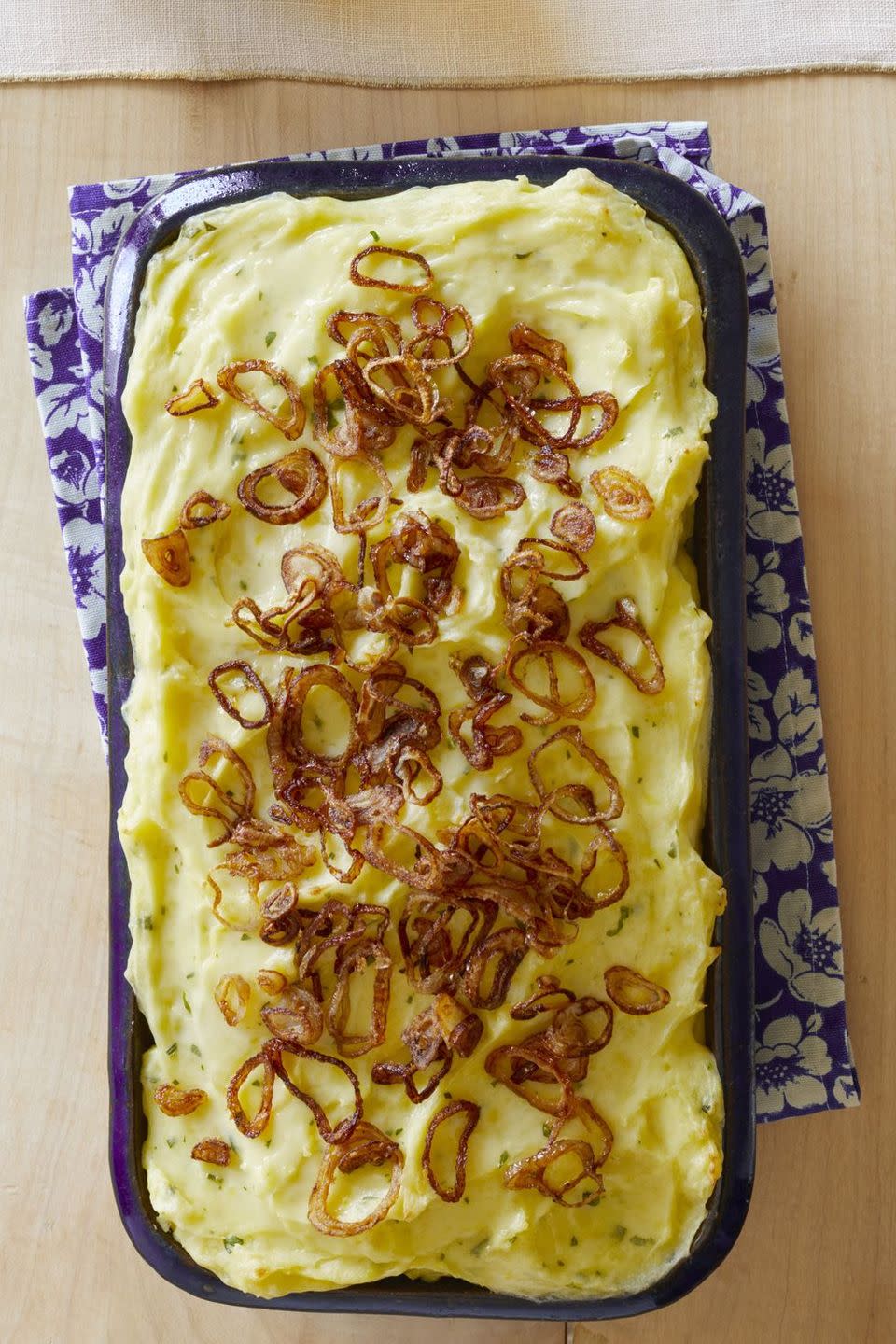 baked mashed potatoes with crispy shallots in blue casserole dish