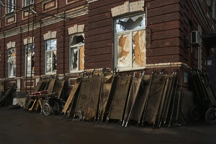 Stretchers are seen outside a city hospital, where wounded Ukrainian soldiers are brought for treatment, in Bakhmut, the site of heavy battles with Russian troops, in the Donetsk region, Ukraine, Friday, Dec. 9, 2022. (AP Photo/LIBKOS)