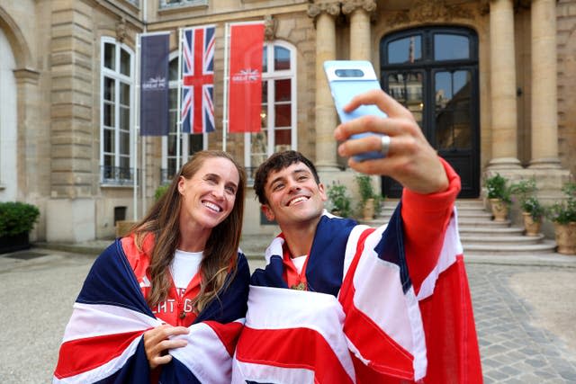 Great Britain flagbearer’s Helen Glover and Tom Daley, draped in Union Jacks with Daley taking a selfie. 