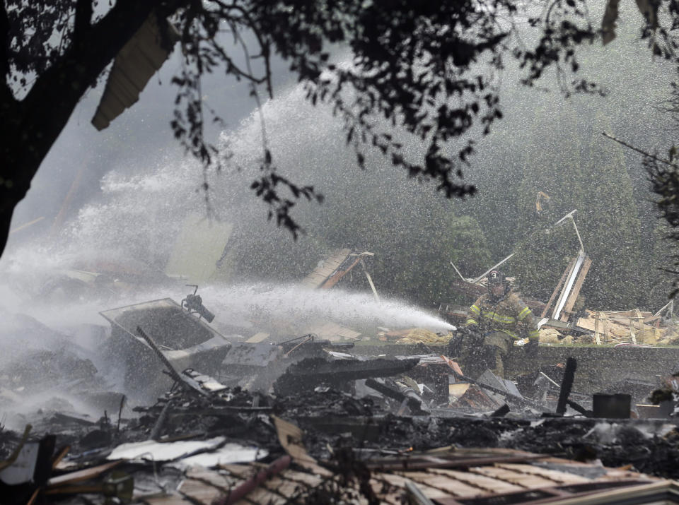 Firefighters and other emergency personnel work at the site of house explosion in Ridgefield, N.J., Monday, June 17, 2019. A home in northern New Jersey has been leveled by an explosion, but the lone person inside the residence apparently escaped serious injury. (AP Photo/Seth Wenig)
