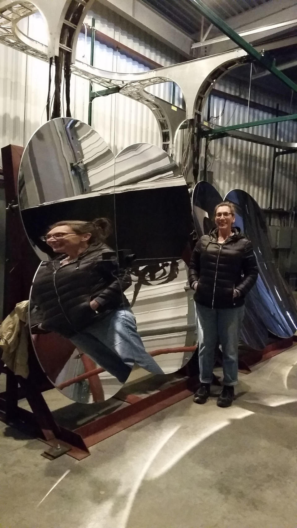 Callahan poses near one of the cloverleaf mirrors used in the fluorescent telescopes that look for flashes of light created when cosmic rays interact with atoms in Earth's atmosphere. <cite>Nola Taylor Redd</cite>