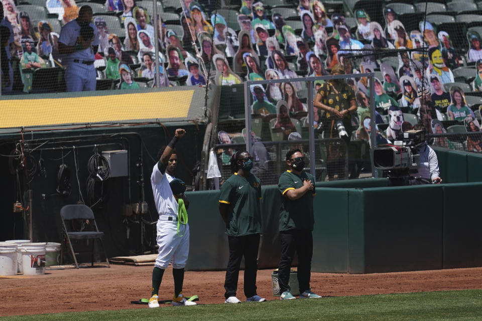 Oakland Athletics' Khris Davis raises his fist during the national anthem before a baseball game between the Athletics and the Los Angeles Angels in Oakland, Calif., Saturday, July 25, 2020. (AP Photo/Jeff Chiu)