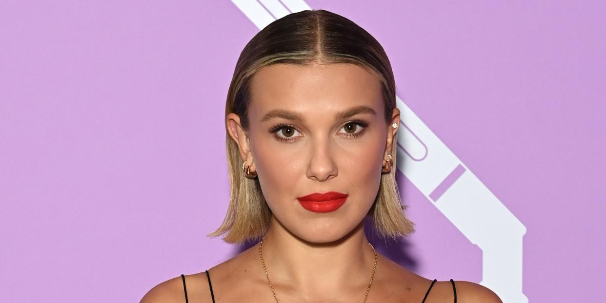 millie bobby brown with blonde bob and red lip poses for carpet