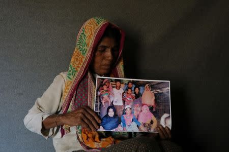 Ayesha Khatun, a Rohingya refugee, holds a family picture that she has sent to her husband and son jailed in Sittwe prison in Myanmar as a reply message, in Cox's Bazar, Bangladesh, July 5, 2018. Picture taken July 5, 2018. REUTERS/Mohammad Ponir Hossain