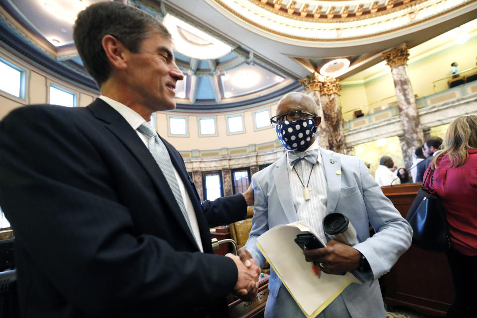 FILE - In this June 28, 2020, file photo, Sen. Briggs Hopson, R-Vicksburg, left, is congratulated by Sen. Hillman Frazier, D-Jackson after the Senate voted to change the Mississippi state flag at the Capitol in Jackson, Miss. Hopson presented the bill to the body. Both chambers of the Mississippi Legislature passed the bill to take down the state flag, which contains the Confederate battle emblem. (AP Photo/Rogelio V. Solis, File)