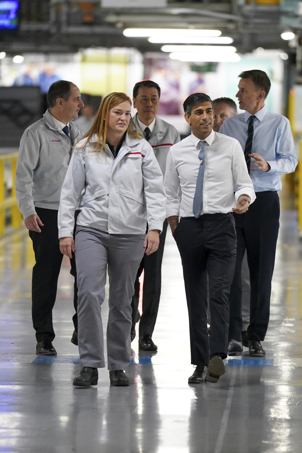 Britain's Prime Minister Rishi Sunak, right and Chancellor of the Exchequer Jeremy Hunt, background right, are shown around, during a visit to the car manufacturer Nissan, in Sunderland, England, Friday, Nov. 24, 2023. Nissan will invest more than $1.3 billion to update its factory in northeast England to make electric versions of its two best-selling cars. It's a boost for the British government as it tries to revive the country’s ailing economy. The Japanese automaker manufactures the gasoline-powered Qashqai and smaller Juke crossover vehicles at the factory in Sunderland, which employs 6,000 workers. (Ian Forsyth/Pool Photo via AP)