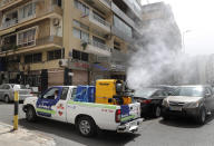 A pickup-mounted machine sprays disinfectant to help prevent the spread of the coronavirus, on a street in Beirut, Lebanon, Tuesday, March 31, 2020. In Lebanon, a criminal court ordered the release of 46 prisoners who were being held without trial to protect them from getting infected, the state-run National News Agency reported. (AP Photo/Hussein Malla)