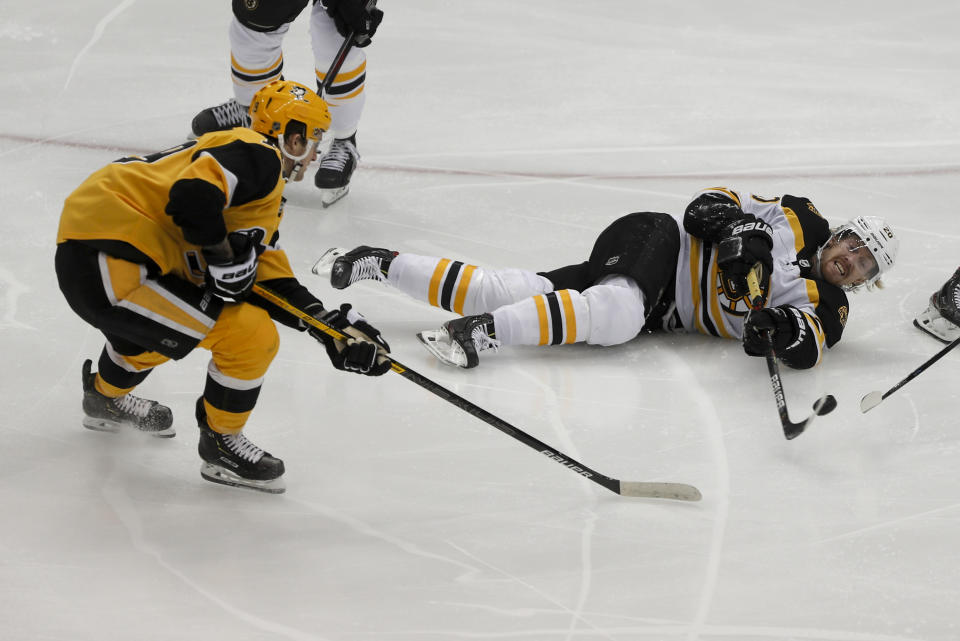 Boston Bruins' Joakim Nordstrom (20) passes the puck from the ice as Pittsburgh Penguins' Jared McCann defends during the first period of an NHL hockey game, Sunday, Jan. 19, 2020, in Pittsburgh. (AP Photo/Keith Srakocic)