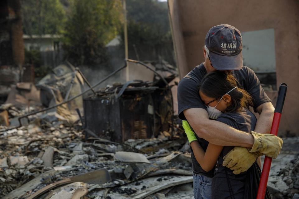 <p>Jeff Lipscomb assures his daughter Rachel Lipscomb, 11, that everything will be ok and that the family will pull through, as they survey their destroyed home after a brush fire on Dec. 6, 2017 in Ventura, Calif. (Photo: Marcus Yam/Los Angeles Times via Getty Images) </p>