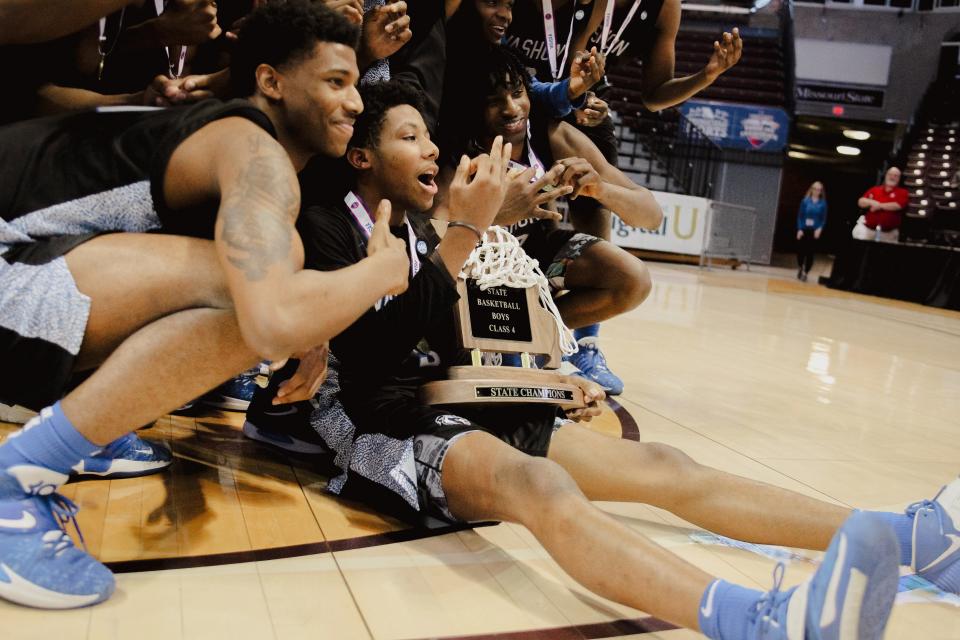 The Vashon boys basketball team celebrates with the Class 4 2022 MSHSAA state championship trophy after defeating Father Tolton at JQH Arena on March 19, 2022.