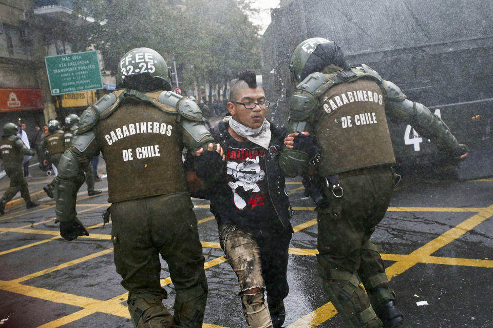 <p>A student is detained by police after throwing an object at them during a protest march demanding the government overhaul the education funding system that would include canceling their student loan debt, in Santiago, Chile, May 9, 2017. Some students stay in debt for up to 20 years after completing their studies. (AP Photo/Esteban Felix) </p>