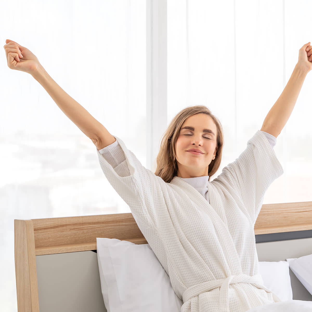 woman waking up and stretching feeling energized