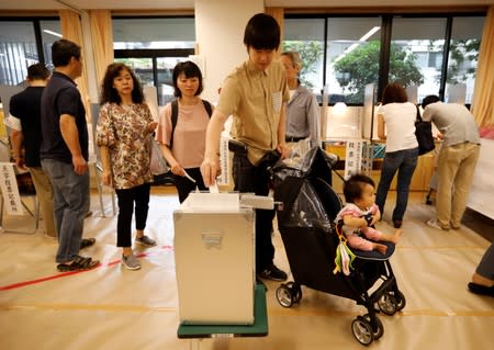 A voter casts a ballot at a voting station during Japan's upper house election in Tokyo