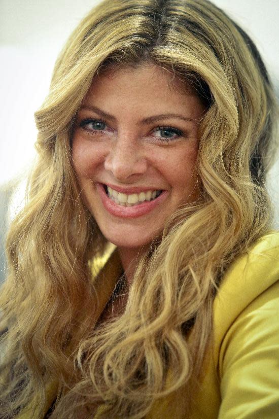 This May 21, 2013 photo shows Alisha Levine with a wavy beach-like hairstyle at Dream Dry salon in New York. When it comes to hair, the grass often seems greener on the other side, but experts say both curly and straight looks require a little work. (AP Photo/Bebeto Matthews)