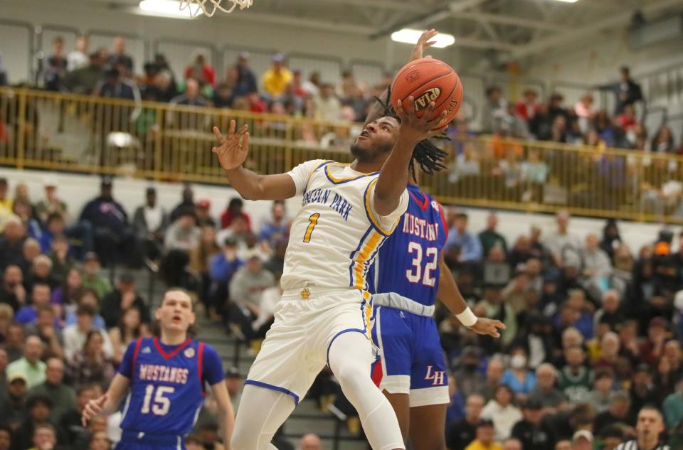 Lincoln Park's DeAndre Moye (1) goes for a layup after getting around Laurel Highland's Antwan Black (32) during the first half of the PIAA 4A Quarterfinals game Friday night at Hampton High School in Allison Park, PA.