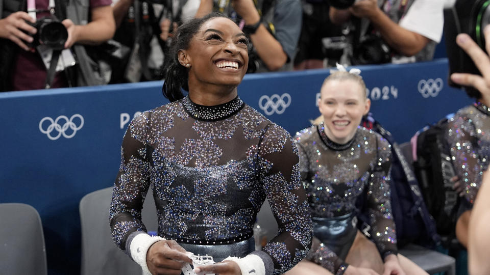 Biles flashes a big smile after competing on the uneven bars at the Summer Olympics. 