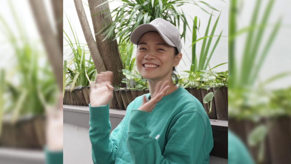 Actress Felicia Chin in green top wearing a white cap and waving at the camera