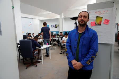 Raphael Roig, territorial development officer at Simplon.co, poses in front of a web development class during an interview with Reuters at the Simplon school specialized in digital sector in Montreuil, near Paris, France, June 14, 2018. Picture taken June 14, 2018. REUTERS/Philippe Wojazer