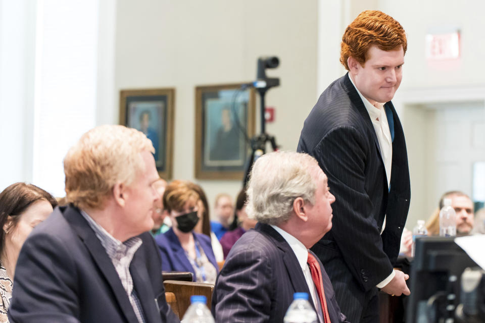 Buster Murdaugh, right, the son of Alex Murdaugh, walks to the witness stand as his father, left, looks on during his trial at the Colleton County Courthouse in Walterboro, S.C., on Tuesday, Feb. 21, 2023. The 54-year-old attorney is standing trial on two counts of murder in the shootings of his wife and son at their Colleton County, S.C., home and hunting lodge on June 7, 2021. (Jeff Blake/The State via AP, Pool)