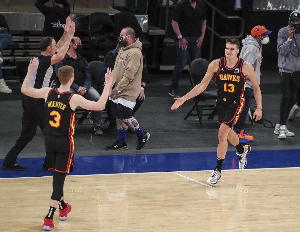 Atlanta Hawks guard Bogdan Bogdanovic (13) celebrates with guard Kevin Huerter (3) after making a 3-point basket against the New York Knicks to tie the score during the fourth quarter of an NBA basketball game Wednesday, April 21, 2021, in New York. (Wendell Cruz/Pool Photo via AP)