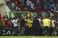 Security and Confederation of African Football (CAF) officials try to protect Ghana fans after Equatorial Guinea fans threw objects during their African Nations Cup semi-final soccer match in Malabo February 5, 2015. REUTERS/Amr Abdallah Dalsh