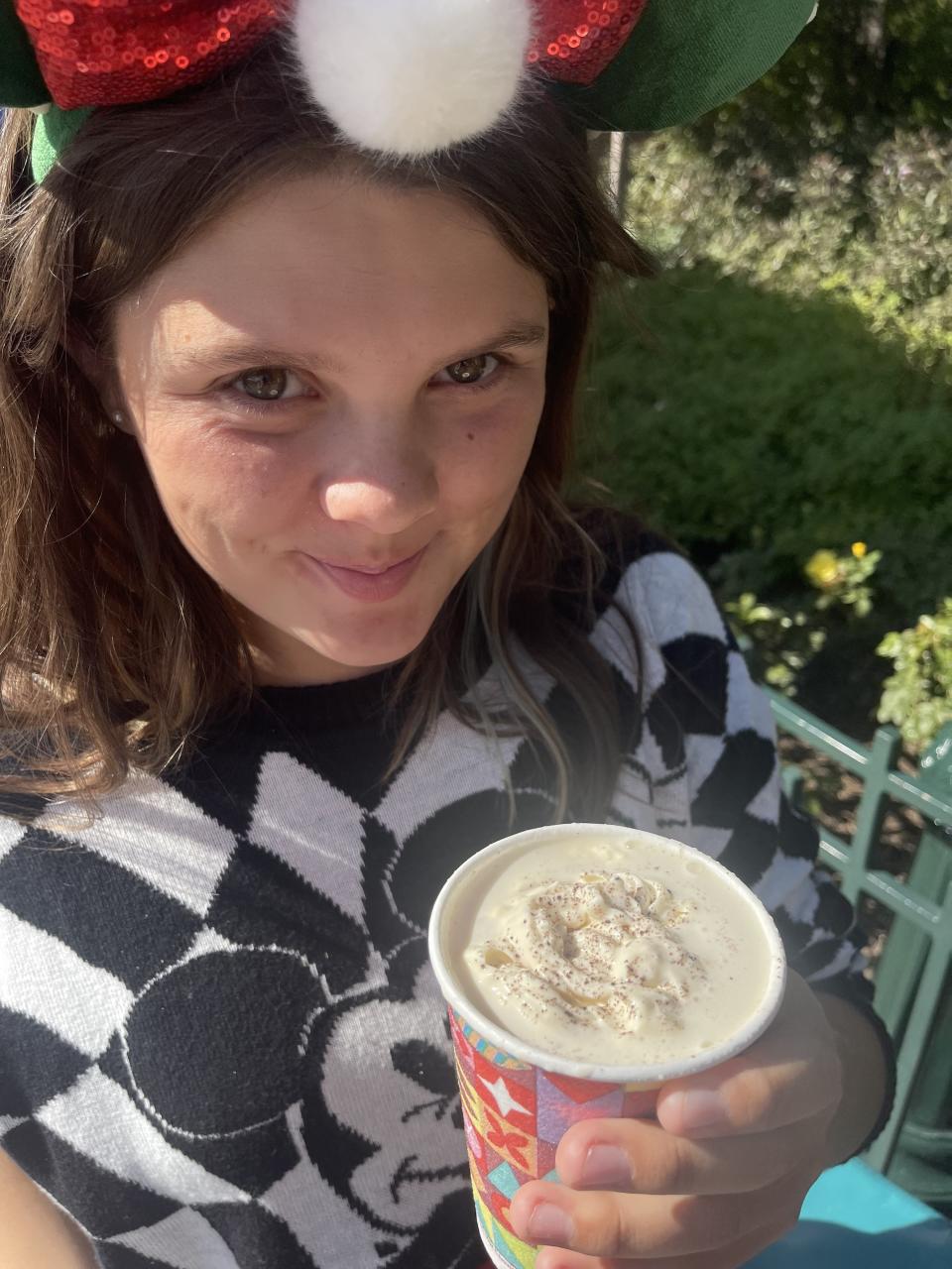 the author's daughter smiling and holding a cup of hot chocolate