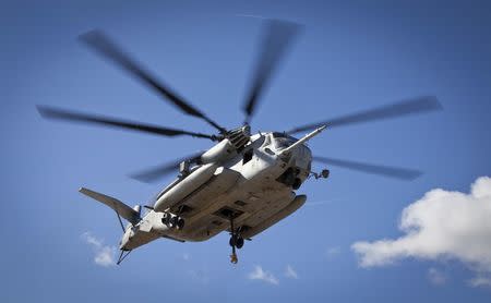 A CH-53E Super Stallion, used by the Marine Heavy Helicopter Squadron 463, prepares to carry off a U.S. Army Huey Helicopter during a sling load operation aboard Barber's Point Naval Air Station, Marine Corps Base Hawaii on September 23, 2014, in this handout photo provided by the U.S. Marine Corps. REUTERS/U.S. Marine Corps/Lance Cpl. Aaron S. Patterson/Handout via Reuters
