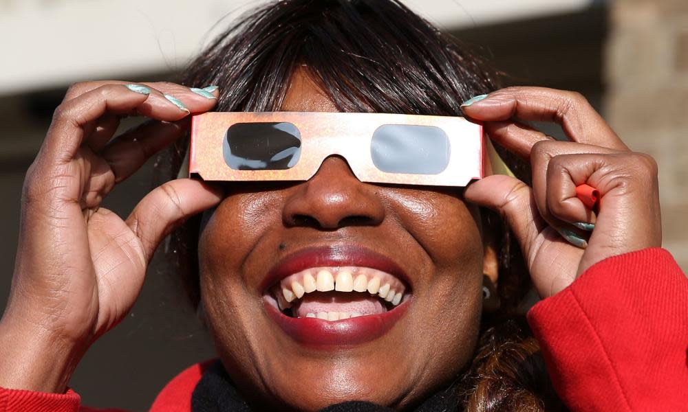 A woman watches an eclipse of the sun.