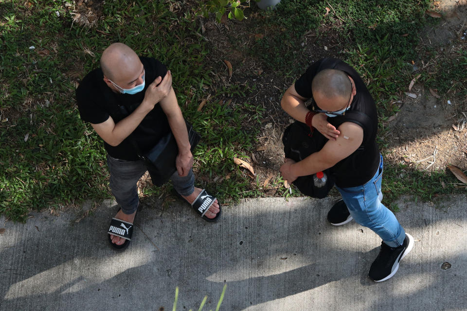 Two men wait outside a clinic after receiving the the China made COVID-19 Sinovac vaccine on June 24, 2021 in Singapore. Singapore allowed the usage of the Sinovac vaccine under the Special Access Route (SAR) framework even though the vaccine remains unregistered and is not authorised by the Health Sciences Authority (HSA). Under the SAR, COVID-19 vaccines approved by the World Health Organisation (WHO) for Emergency Use List (EUL) can be imported and supplied by private healthcare institutions. This will allow individuals an alternative to choose other than the city state approved vaccine, such as Pfzer-BioNTech and Moderna. (Photo by Suhaimi Abdullah/NurPhoto via Getty Images)