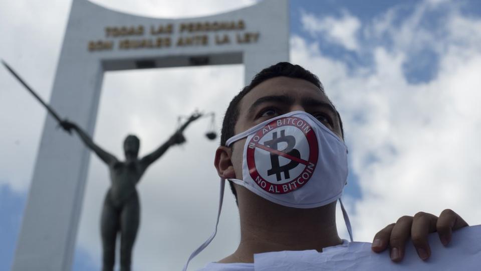 Un hombre con mascarilla en contra del Bitcoin.