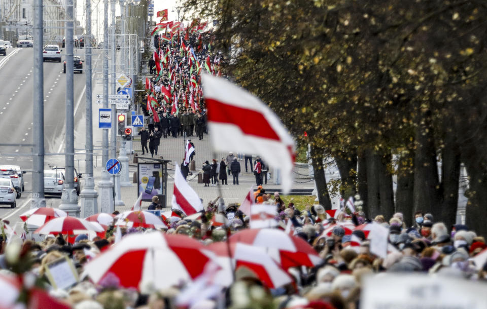 Opposition supporters, foreground, and supporters of Belarusian President Alexander Lukashenko, background, rally in Minsk, Belarus, Monday, Oct. 19, 2020. The elderly rallied in Minsk once again on Monday to demand resignation of the country's President Alexander Lukashenko, as mass protests triggered by a disputed election continue to rock Belarus. Lukashenko's older supporters also gathered in the country's capital Monday for a pro-government rally. (AP Photo)