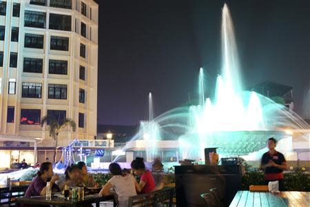 Locals enjoy the evening in one of the nearby restaurants around the Nam Phou fountain in Vientiane October 26, 2013. REUTERS/Aubrey Belford