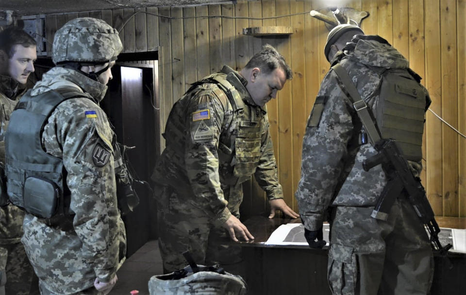 In this photo taken on Nov. 19, 2021, Attache of the Land Forces at the US Embassy in Ukraine Colonel Brandon Presley looks at the map during the visit by a delegation of the US Embassy in Ukraine to the Joint Forces operation area in the war-hit Donetsk region, Ukraine. The Kremlin has voiced concern about a possible escalation of fighting in eastern Ukraine's separatist conflict as the U.S. issued a strong warning to Russia to stay away from Ukraine. Ukrainian and Western officials have worried about a Russian troop buildup near Ukraine could herald an invasion.(Ukrainian Joint Forces Operation Press Service via AP)