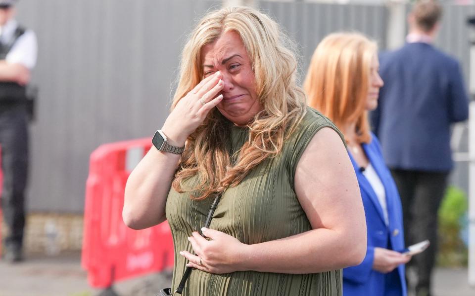 One local is pictured in tears as she visits the scene of the stabbing in Southport