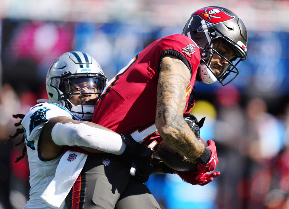 Tampa Bay Buccaneers wide receiver Mike Evans, right, hangs onto a pass as Carolina Panthers linebacker Shaq Thompson, left, makes the stop during the first half of an NFL football game Sunday, Oct. 23, 2022, in Charlotte, N.C. (AP Photo/Jacob Kupferman)