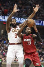 Miami Heat's Bam Adebayo (13) drives past Cleveland Cavaliers' Andre Drummond (3) in the second half of an NBA basketball game, Monday, Feb. 24, 2020, in Cleveland. (AP Photo/Tony Dejak)