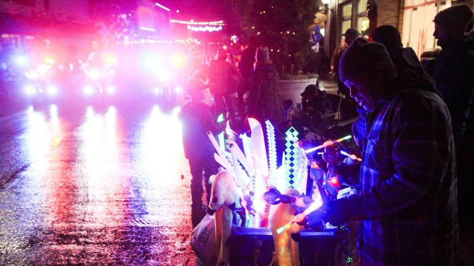 San Luis Obispo Police Department motorcycle officers start the parade as a lighted souvenir vendor works nearby. The 46th annual Holiday Parade, under the theme “Rockin’ Retro Holidays,” took to the San Luis Obispo streets Dec. 2, 2022.