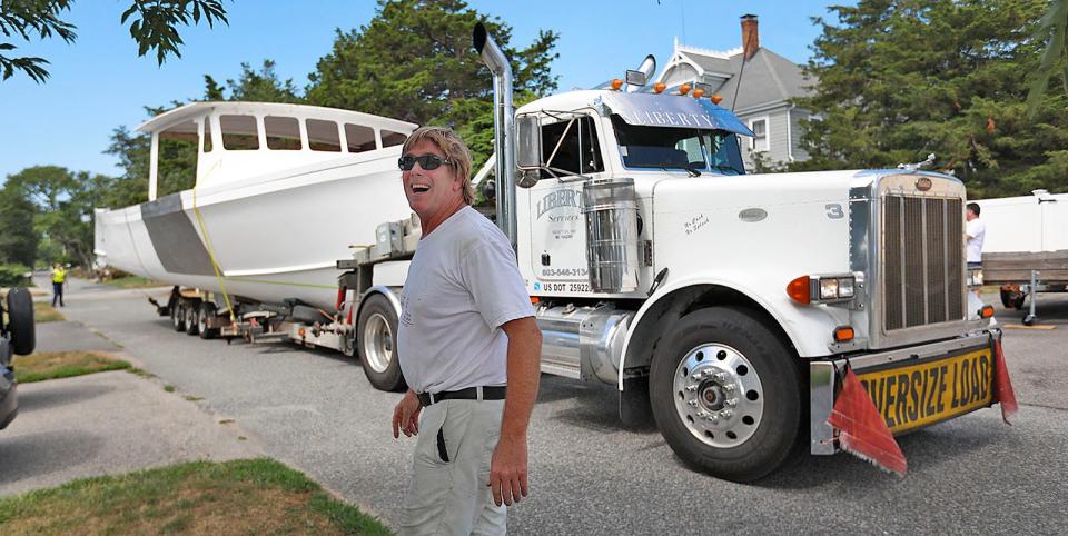 Marshfield lobsterman Andy Glynn shares a laugh with a neighbor who thought he should have gotten a "bigger boat." Glynn's new boat is named Bre-Jay. It's 45 feet long and 17 feet wide. It required a State Police escort from the New Hampshire border to Glynn's Brant Rock home on Aug. 9, 2022.