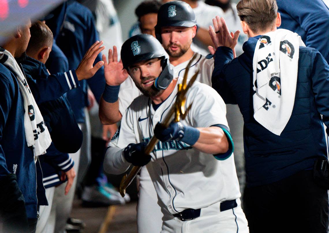 Seattle Mariners left fielder Mitch Haniger (17) holds up the trident in the dugout after hitting a home run against the Boston Red Sox during the fourth inning of the opening day game at T-Mobile Park, on Thursday, March 28, 2024, in Seattle, Wash. Brian Hayes/bhayes@thenewstribune.com