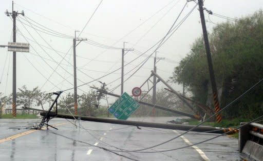 Utility poles lie on the road after being blown down during typhoon Tembin in Taitung, eastern Taiwan, on August 24, 2012. Typhoon Tembin swept across southern Taiwan, toppling trees and ripping off rooftops after thousands of people were evacuated to avoid a repeat of a deadly storm three years ago