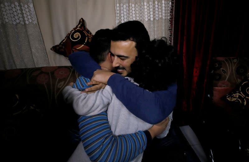 Palestinian journalist, Yaghi, hugs his younger brothers in Banha