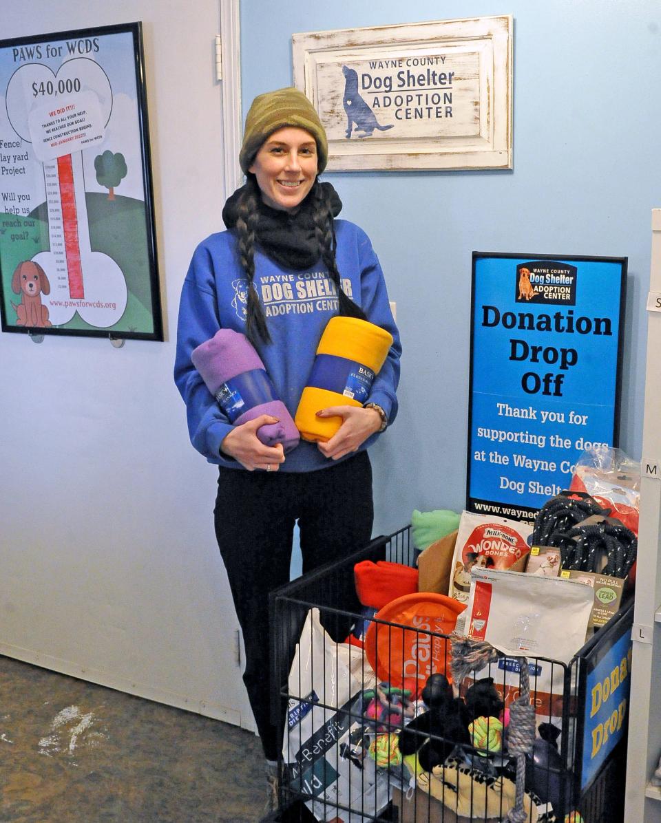 Stephanie Kurzenberger, a worker at the Wayne County Dog Shelter, holds some of the items it has received as part of the "Betty White Challenge." It also has received monetary donations which will buy more supplies like the ones in the photo. Kurzenberger said leashes and collars are always needed.