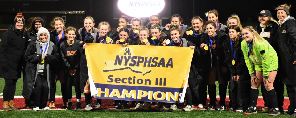 The Rome Free Academy Black Knights pose with their championship banner after winning Section III's Class A field hockey final Sunday.