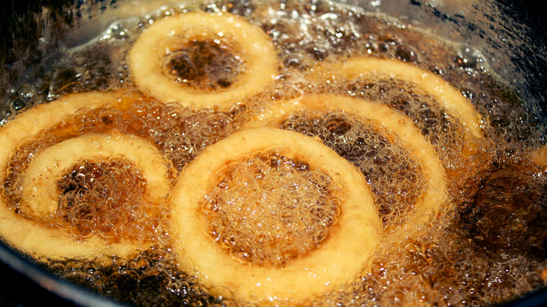 battered onion rings cooking in a deep fryer